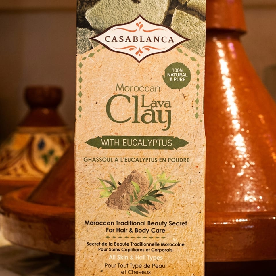 Moroccan Casablanca eucalyptus clay powder displayed alongside traditional pottery and bottles in a warmly lit setting.